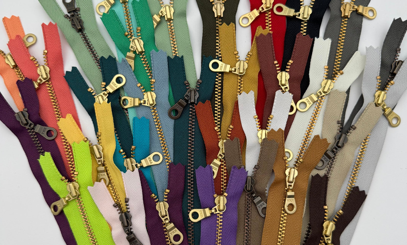 Collection of colorful YKK zippers with gold metal 